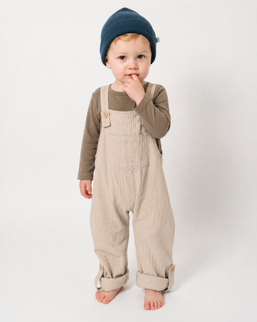 Child wearing organic cotton muslin overalls in Oat neutral – double gauze overalls for babies, toddlers and kids  – Babu